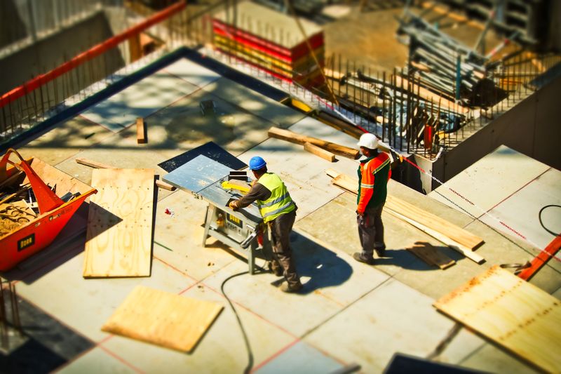 Professionelles Pflasterteam bei der Verlegung von Natursteinen auf einer Baustelle